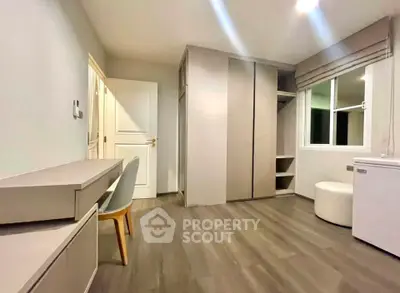 Modern minimalist bedroom with sleek furniture and ample storage space.