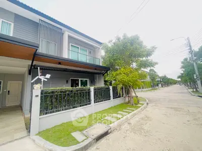 Modern townhouse with sleek design and lush greenery in a serene neighborhood.