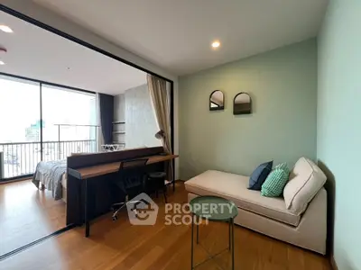 Modern studio apartment with cozy living area and city view balcony.