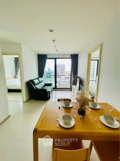 Modern apartment with open living and dining area, featuring a city view from large windows.