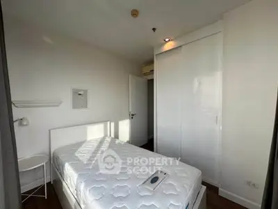 Cozy bedroom with white decor and ample natural light, featuring a built-in wardrobe and minimalist design.