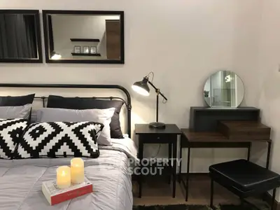 Stylish bedroom with modern decor, featuring a cozy bed, elegant mirrors, and a chic vanity desk.