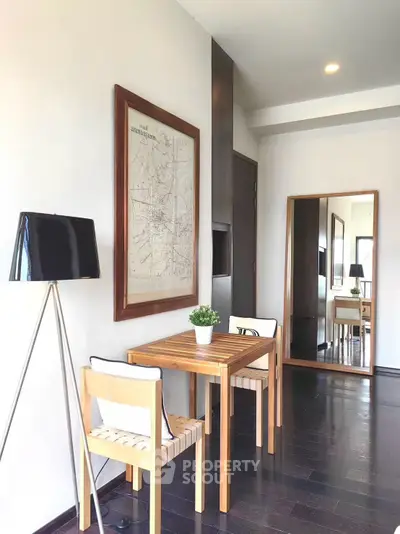 Chic modern dining area with stylish wooden table, elegant chairs, and decorative wall art in a cozy apartment.