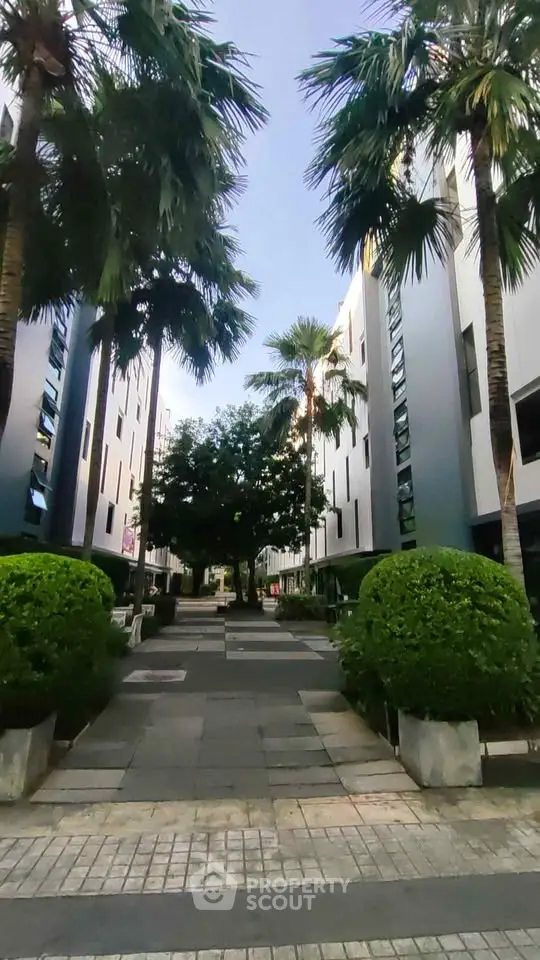 Modern apartment complex with lush greenery and palm trees