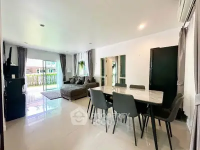Spacious modern living room with dining area and large windows in a stylish apartment.