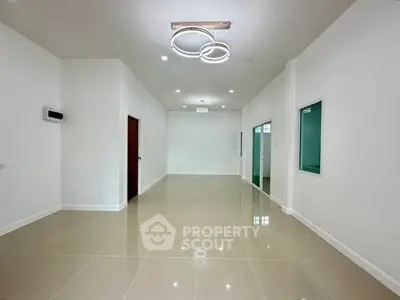 Spacious modern living room with sleek lighting and glossy tiled floors