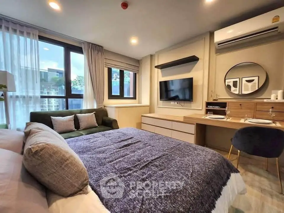 Modern bedroom with stylish decor, large window, and cozy seating area in a contemporary apartment.