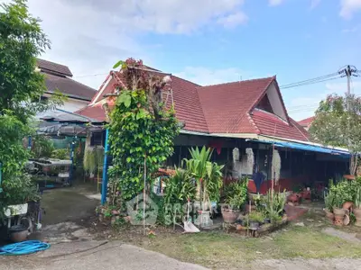 Charming suburban house with lush garden and red-tiled roof, perfect for family living.
