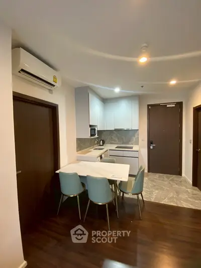 Modern kitchen with dining area in a stylish apartment, featuring sleek cabinetry and contemporary design.