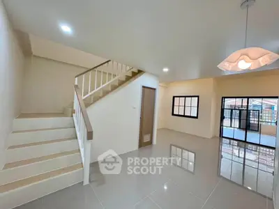 Spacious modern living room with staircase and large windows, perfect for family gatherings.
