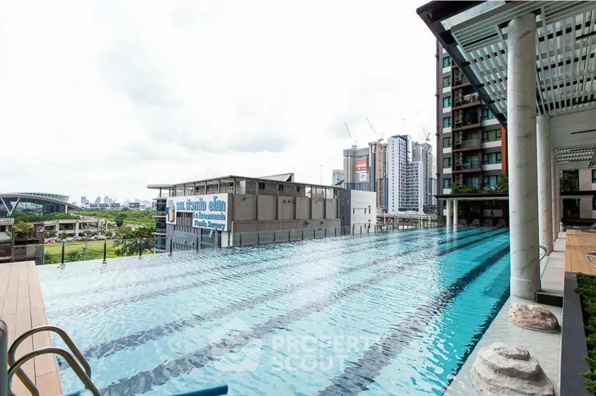 Luxurious high-rise building with stunning infinity pool and cityscape view, perfect for urban living.