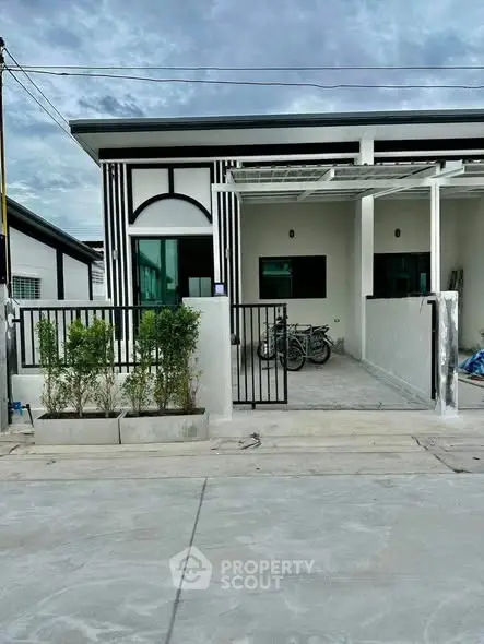 Modern single-story house with sleek design and gated driveway