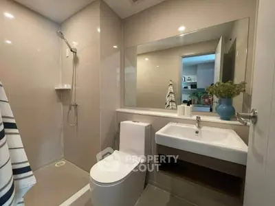 Modern bathroom with sleek fixtures and large mirror in a contemporary home.