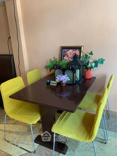 Charming dining area with vibrant yellow chairs and elegant decor, perfect for cozy gatherings.