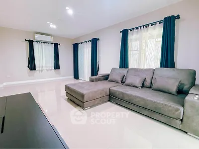 Spacious living room with modern gray sectional sofa and elegant curtains