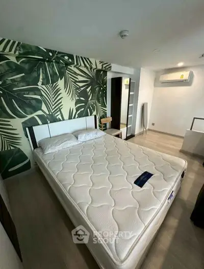 Spacious bedroom with modern decor and tropical accent wall