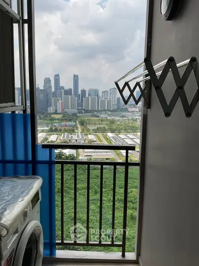 Stunning city skyline view from a high-rise balcony with laundry area.