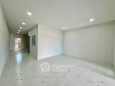 Spacious modern living room with sleek tile flooring and ample natural light.