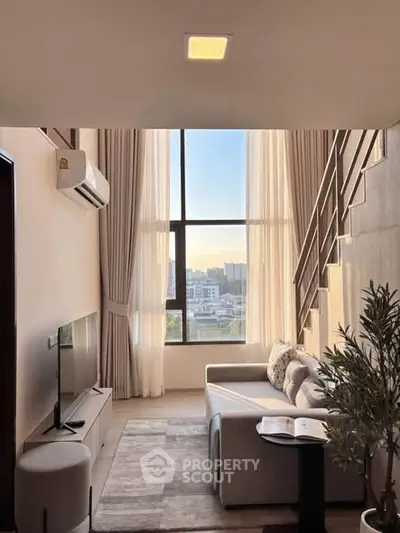Modern living room with high ceilings and large windows offering city views