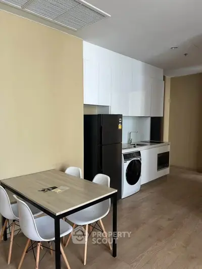 Modern kitchen with sleek appliances and dining area in a stylish apartment.