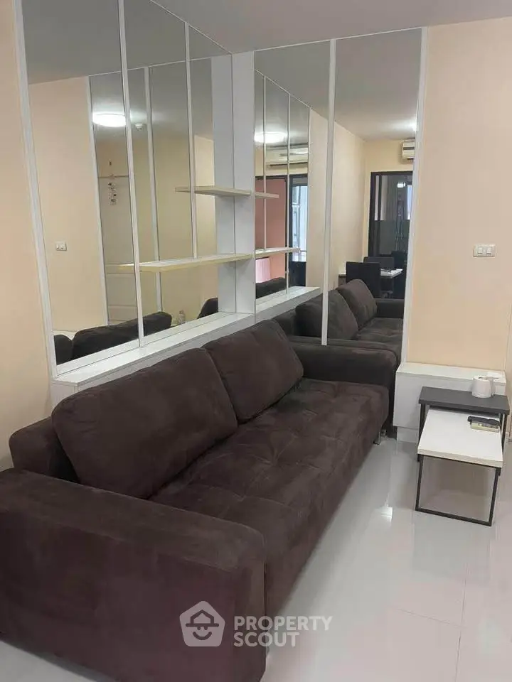 Modern living room with mirrored wall and plush brown sofa