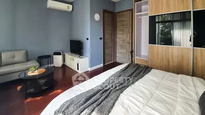 Spacious bedroom with modern decor and cozy seating area