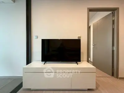 Modern living room with sleek TV stand and open door to hallway