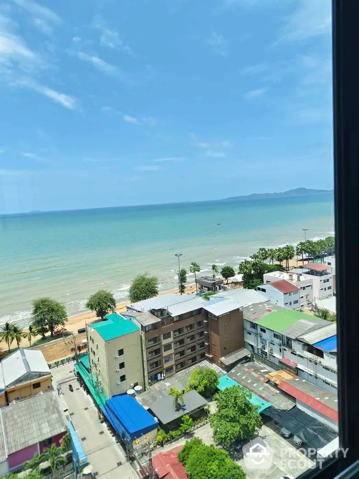 Stunning ocean view from high-rise building overlooking beach and cityscape.