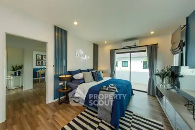 Spacious modern bedroom with balcony access and stylish decor in a contemporary home.