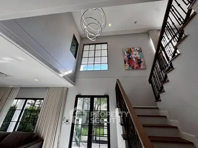 Stunning modern living room with high ceilings and elegant staircase