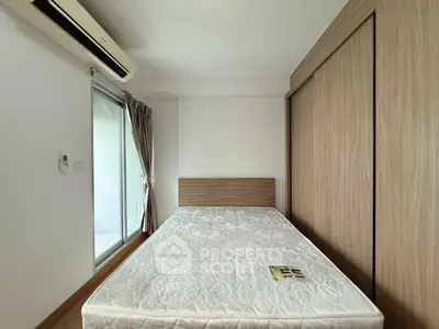 Modern bedroom with minimalist design and large window for natural light.