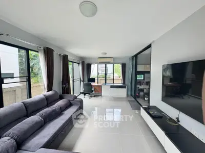 Spacious modern living room with large windows and sleek furniture