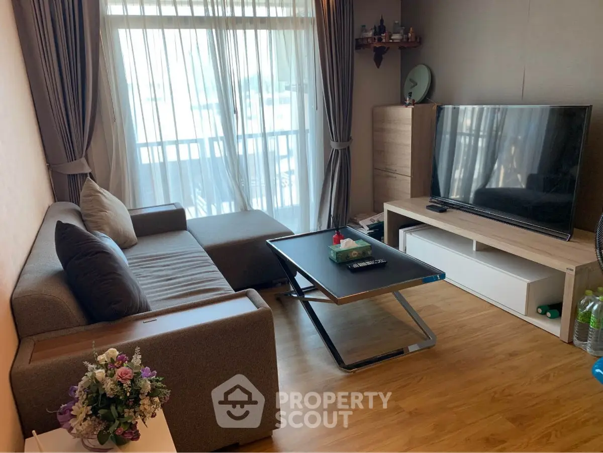 Modern living room with stylish furniture and large TV, perfect for relaxation.