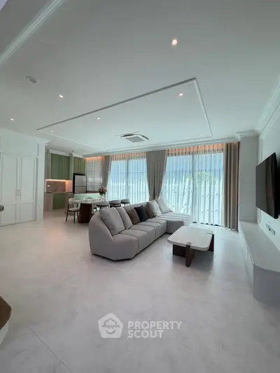 Spacious modern living room with elegant decor and large windows offering natural light.