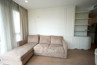 Modern living room with stylish beige sectional sofa and elegant shelving, perfect for cozy relaxation.
