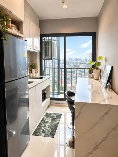 Modern kitchen with sleek design and stunning city view from large window.