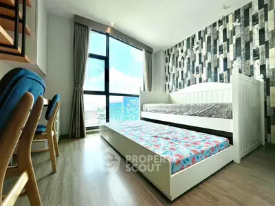 Modern bedroom with trundle bed and large window offering city view