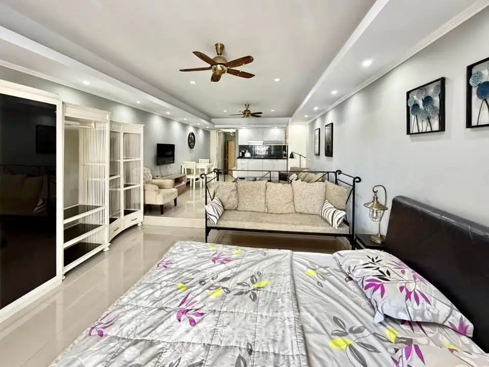 Spacious open-plan living room with modern decor and ceiling fans, perfect for comfortable living.