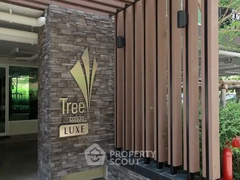 Modern condo entrance with stylish stone and wood design at Tree Condo Luxe.