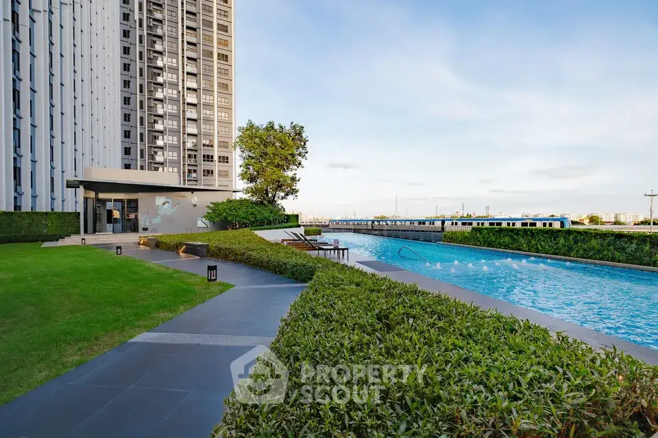 Luxurious high-rise building with stunning pool and lush garden area, perfect for relaxation and leisure.