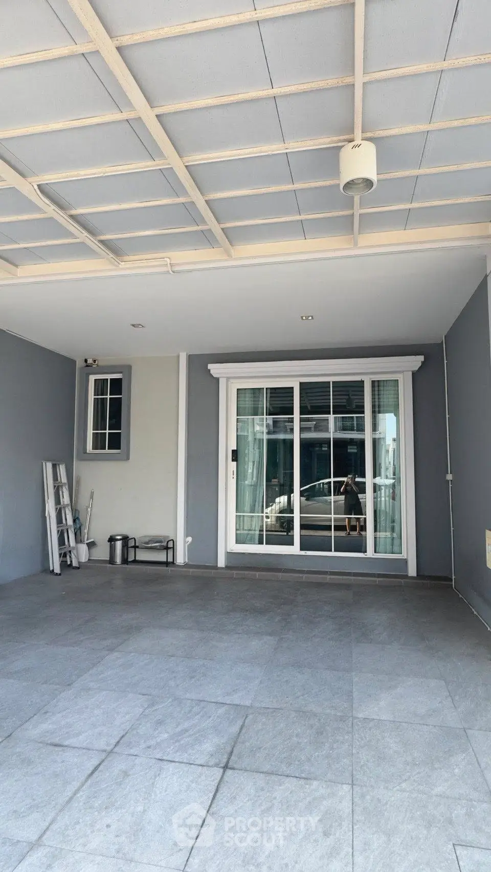 Spacious covered parking area with sliding glass doors and modern design.