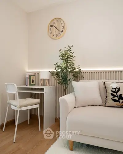 Cozy living room with modern decor, featuring a white sofa, small desk, and stylish wall clock.