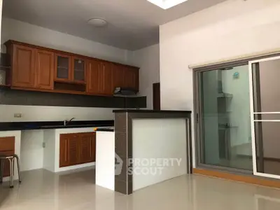 Spacious kitchen with modern open layout and sliding glass doors leading to a bright outdoor area.