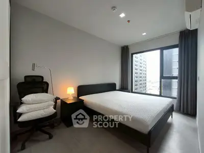 Modern bedroom with large window and city view, featuring a comfortable bed and stylish furnishings.