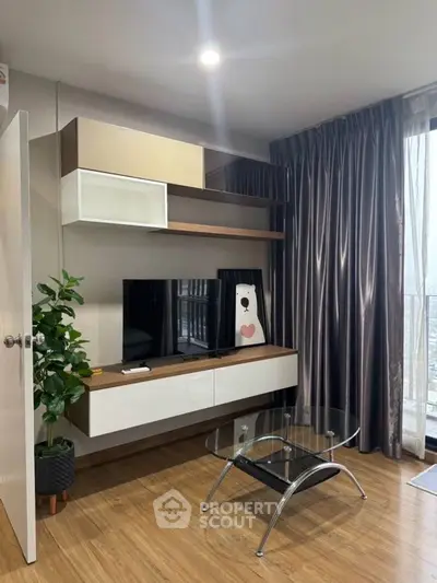 Modern living room with stylish furniture and large window offering natural light and city view.