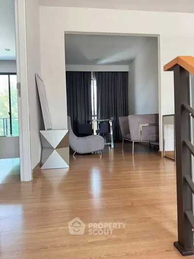 Modern interior with stylish furniture and wooden flooring, featuring a cozy seating area and natural light.