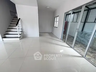 Spacious modern interior with sleek staircase and sliding glass doors