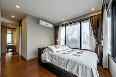 Modern bedroom with city view and stylish decor in high-rise apartment