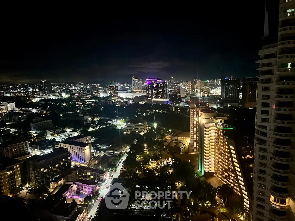 Stunning night cityscape view from high-rise building with illuminated skyline.