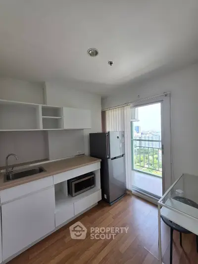 Modern kitchen with sleek appliances and balcony view in a bright apartment